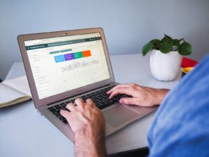 person using macbook air on white table