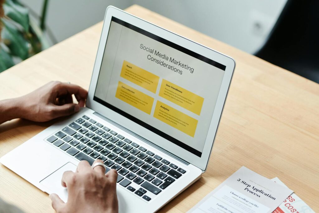 A person using a laptop to review social media marketing strategies at home.