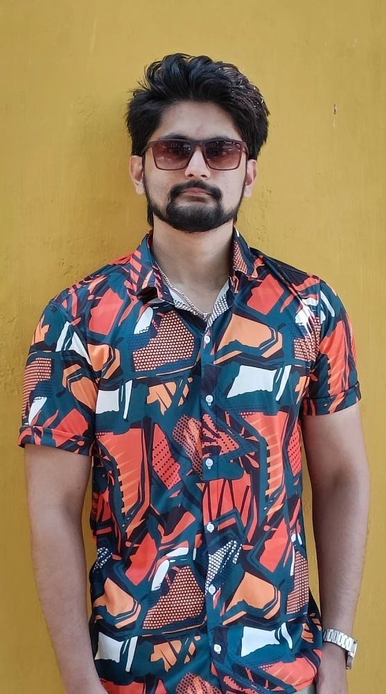 Amar Karthik standing in front of a yellow wall wearing a cool sunglass