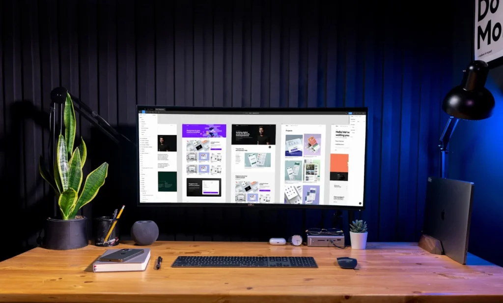 A colorful app layout design is being designed on a large monitor